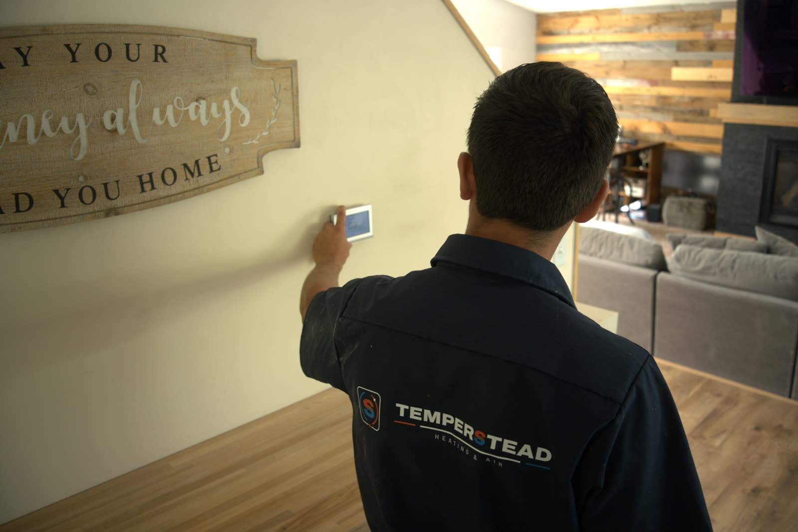 Temperstead technician adjusting a customer's thermostat